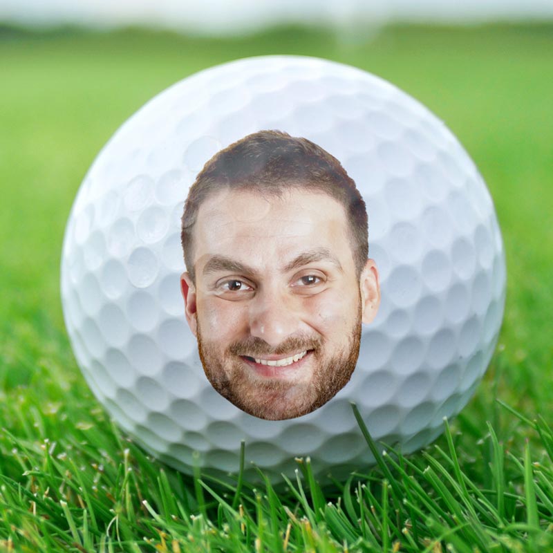 Custom golf ball with a personalized face on green gras