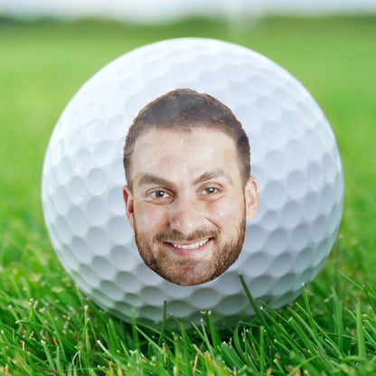Custom golf ball with a personalized face on green gras